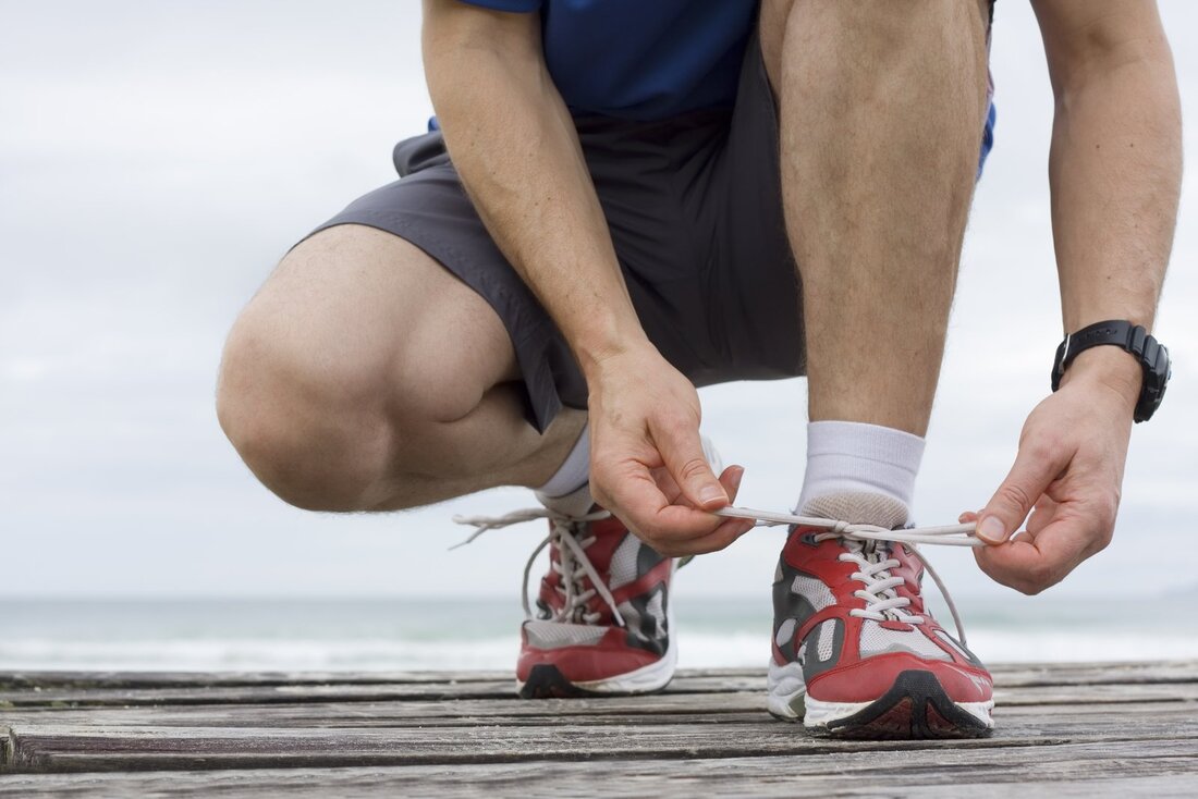 man tying up his shoe lace